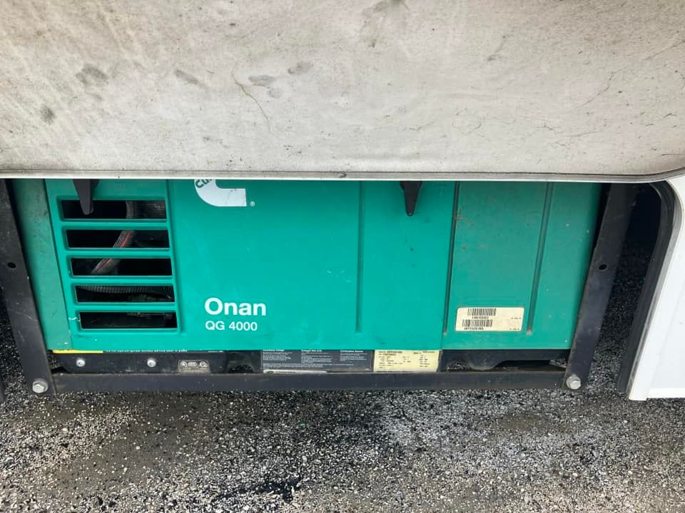 A green Onan generator, model GG 4000, is installed in a recreational vehicle, viewed from below.