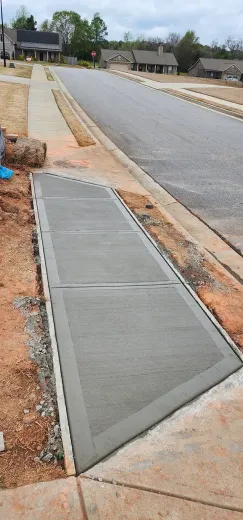 A concrete sidewalk is being built next to a road.