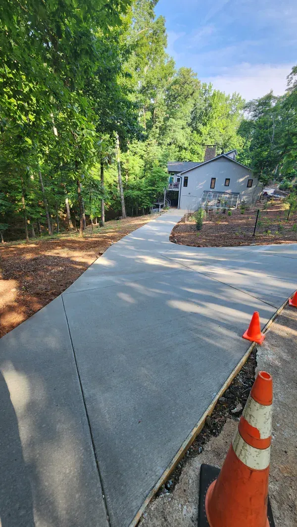 A concrete driveway is being built in front of a house.