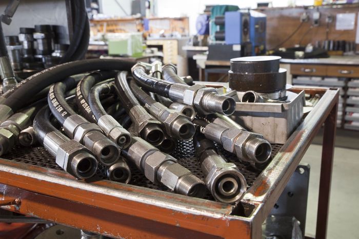 Tubi flessibili e raccordi idraulici in un ambiente di officina.