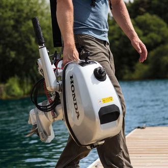 A Man Carries Outboard - Parts & Servicing In Yarrawonga, NT