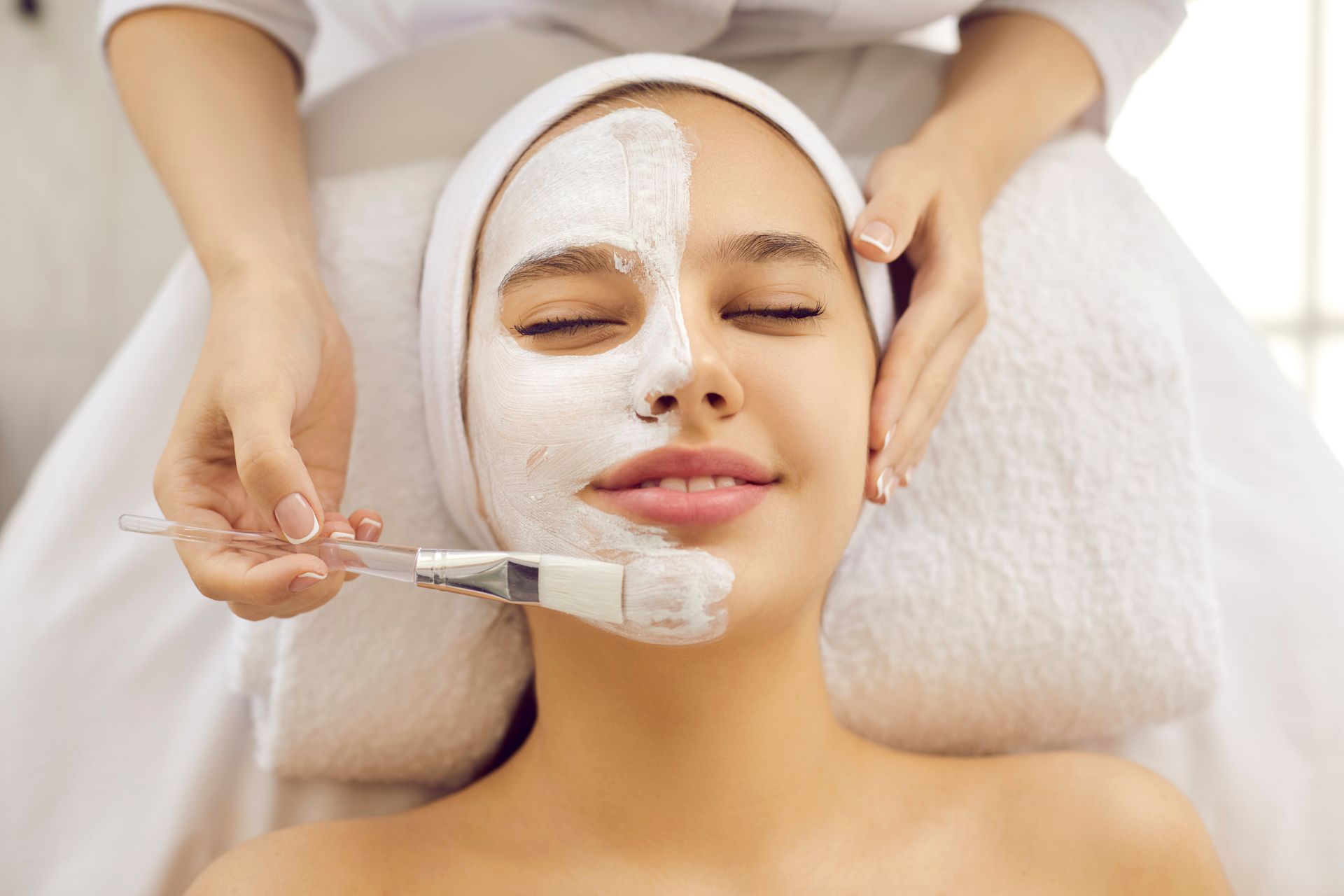 A woman is getting a facial treatment at a spa.