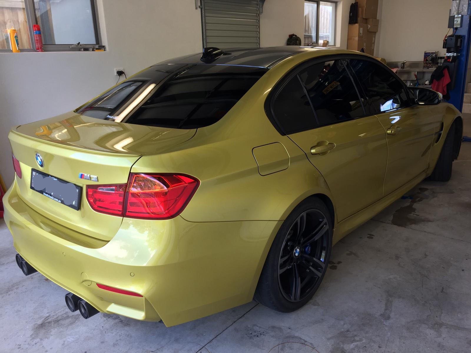 Ceramic tint a gold BMW M3 rear side view