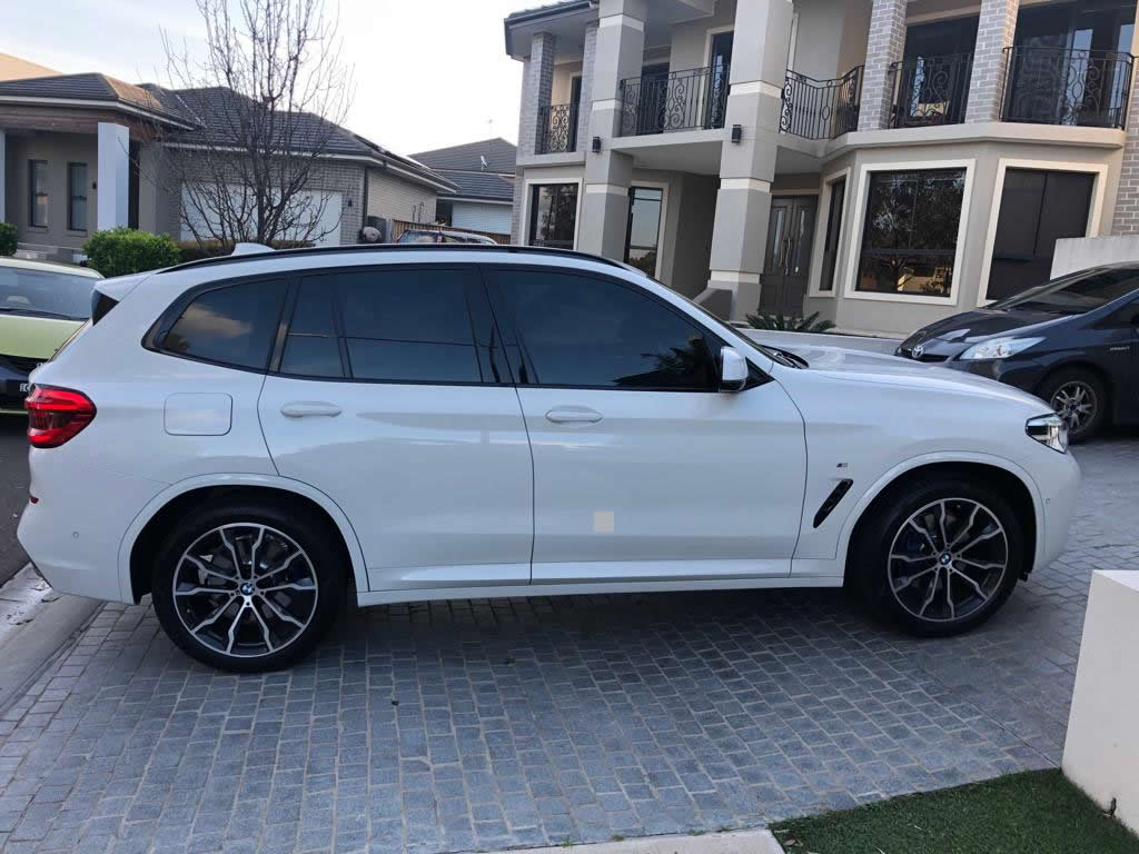 Car tint a white BMW 4x4 side view