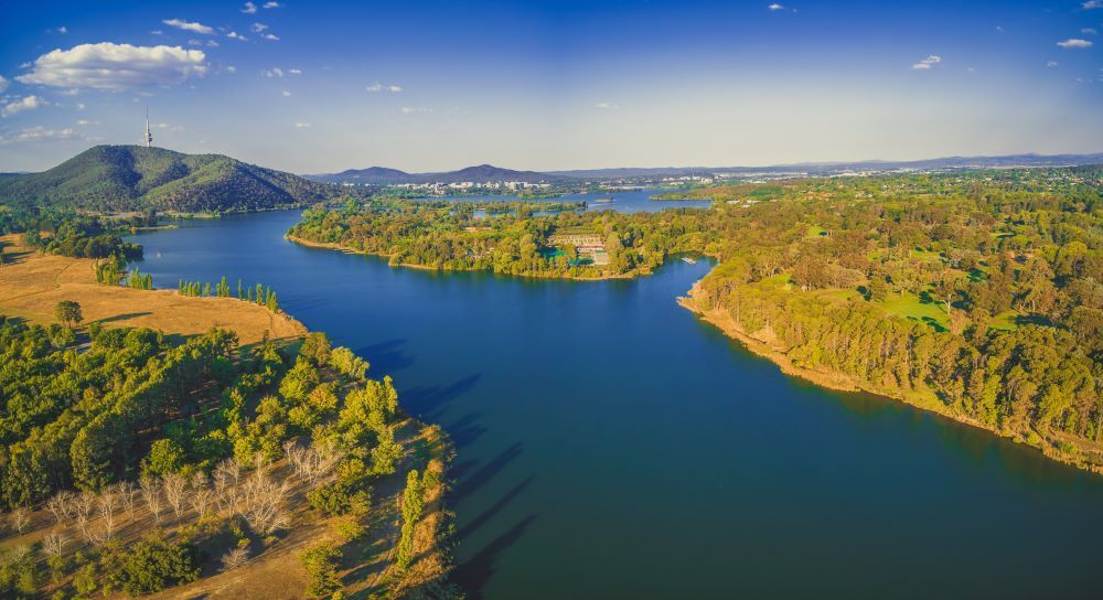 An Aerial View of a Lake Surrounded by Trees and Mountains — Vent Wise in Canberra, ACT