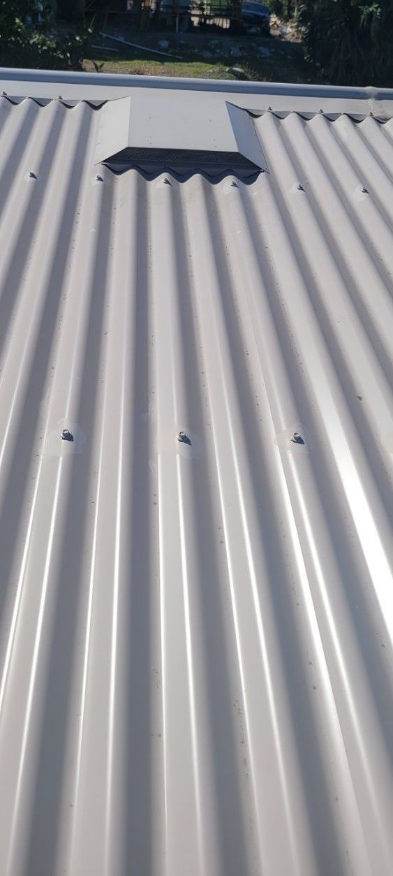 A Close Up of a White Corrugated Metal Roof With a Hole in It — Vent Wise in Twin Waters, QLD