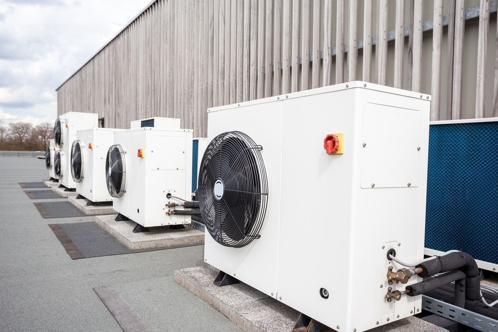 A Row of Air Conditioners Are Sitting on the Roof of a Building — Vent Wise in Twin Waters, QLD