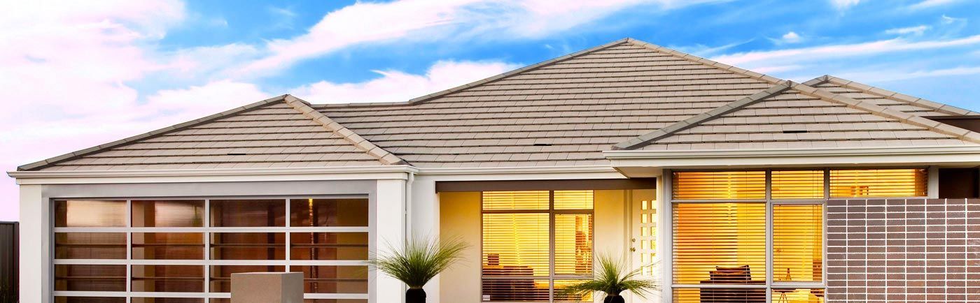 Modern house exterior with glass windows, light walls, and angled roof under blue sky.— Vent Wise in Twin Waters, QLD
