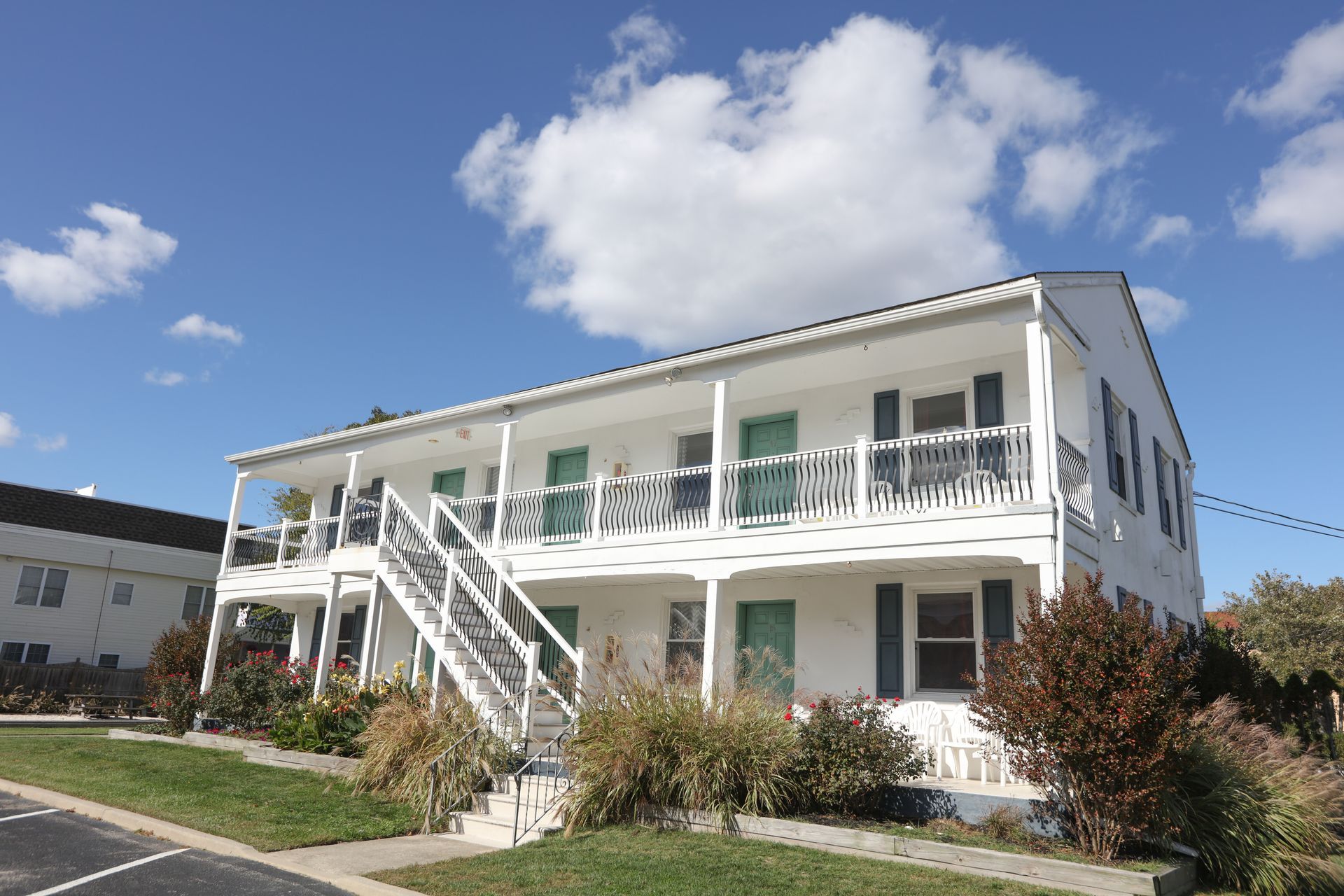 A large white house with stairs leading up to the second floor