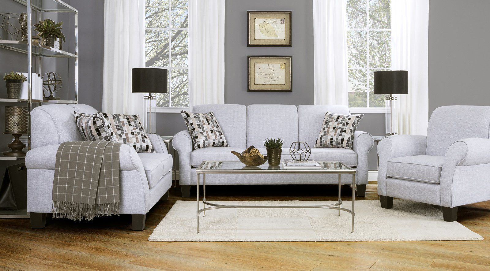 A living room with white furniture and gray walls
