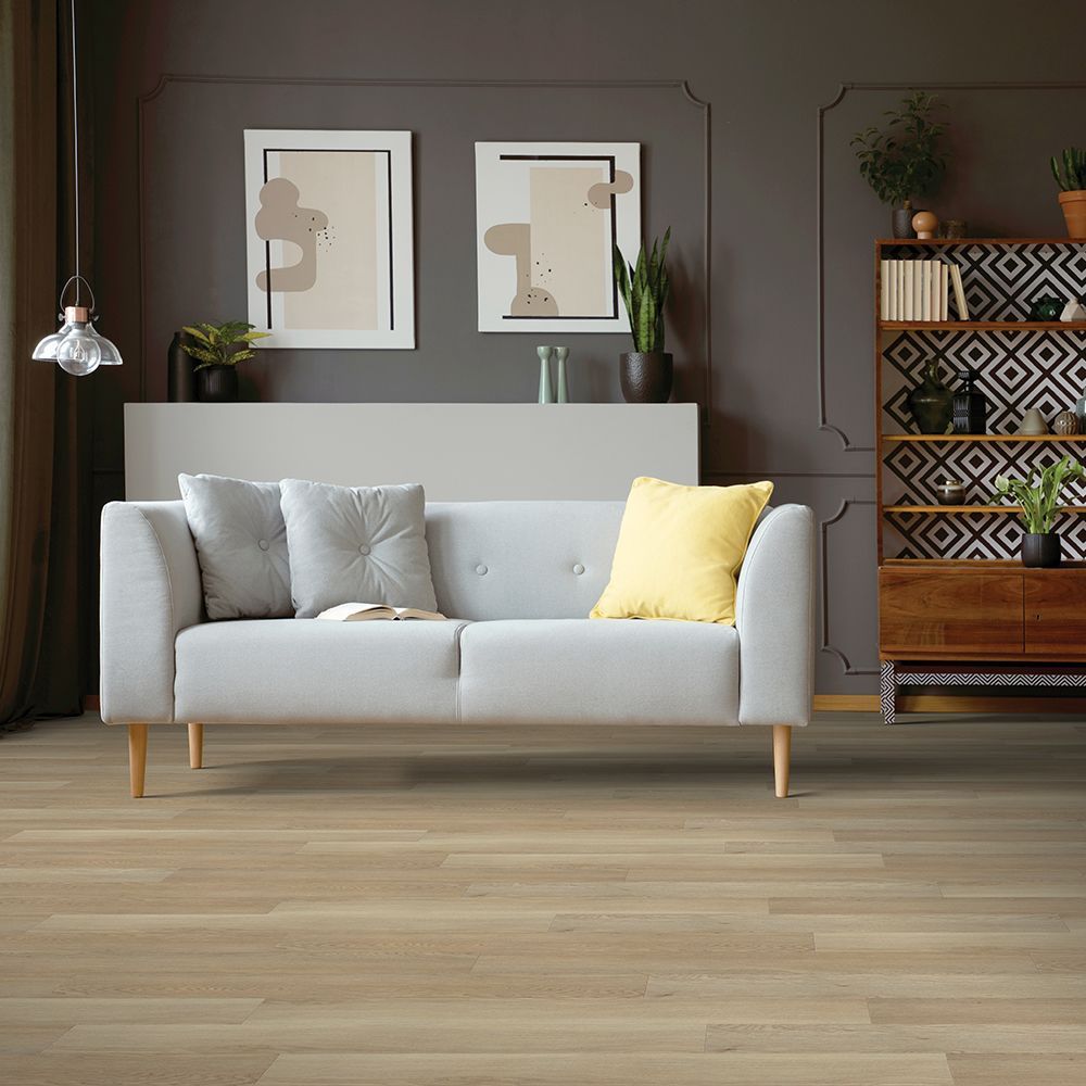 A living room with a white couch and a wooden floor.