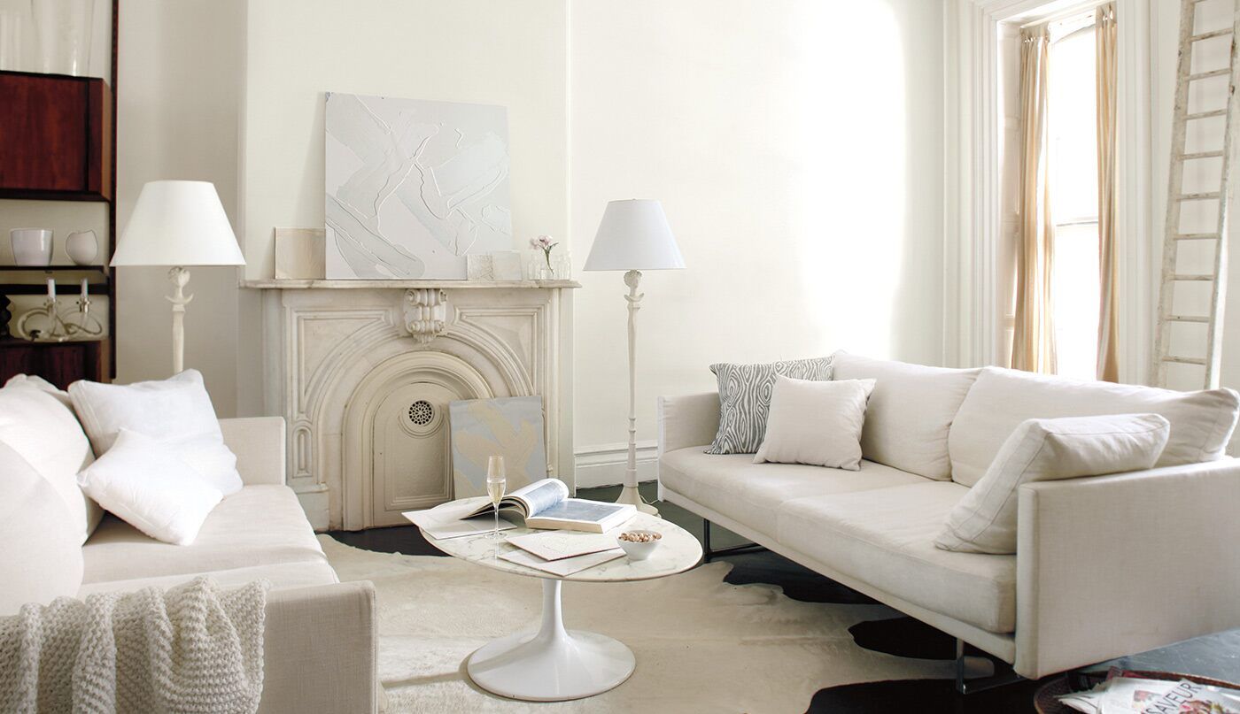 A living room with white furniture and a fireplace
