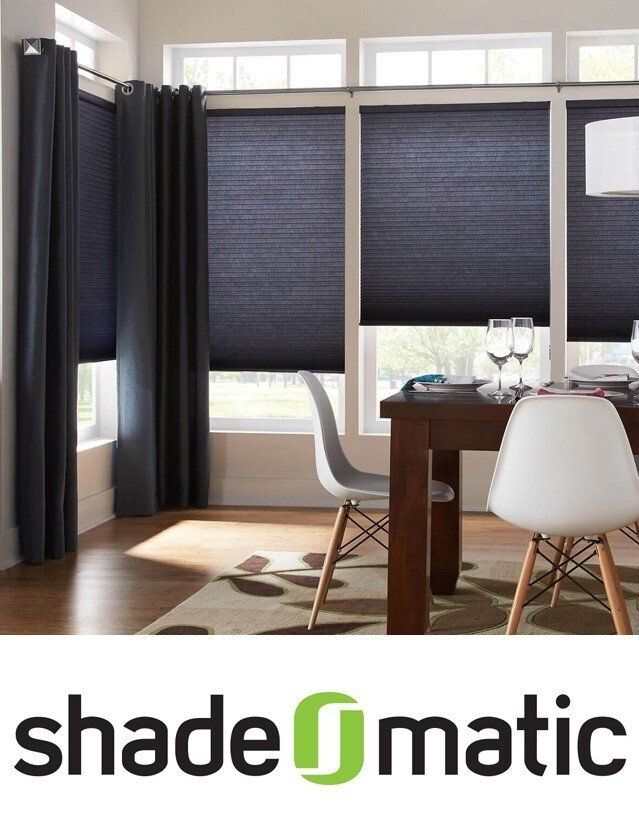 A dining room with shade matic shades on the windows