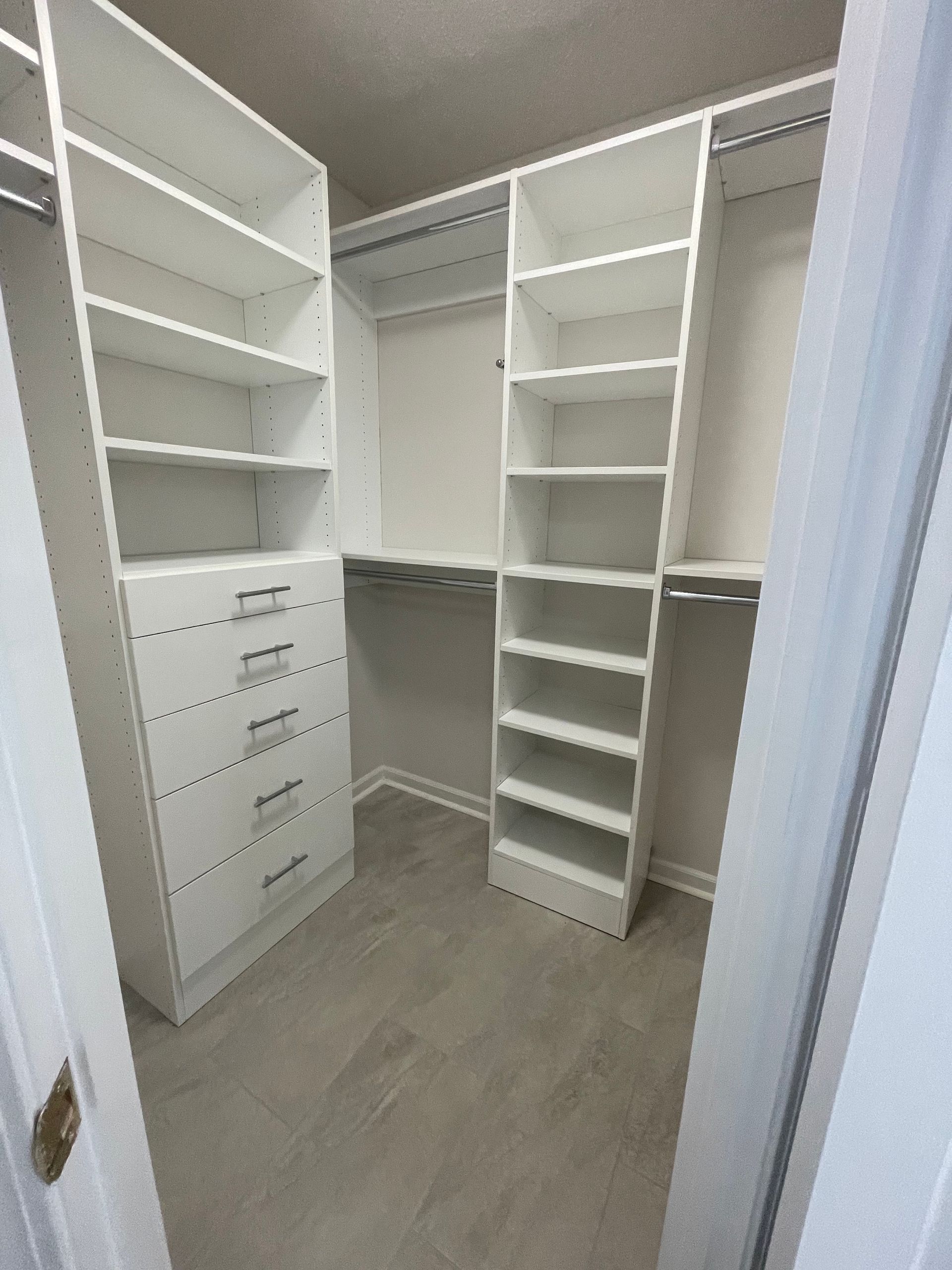 White closet organization system with shelves and drawers.