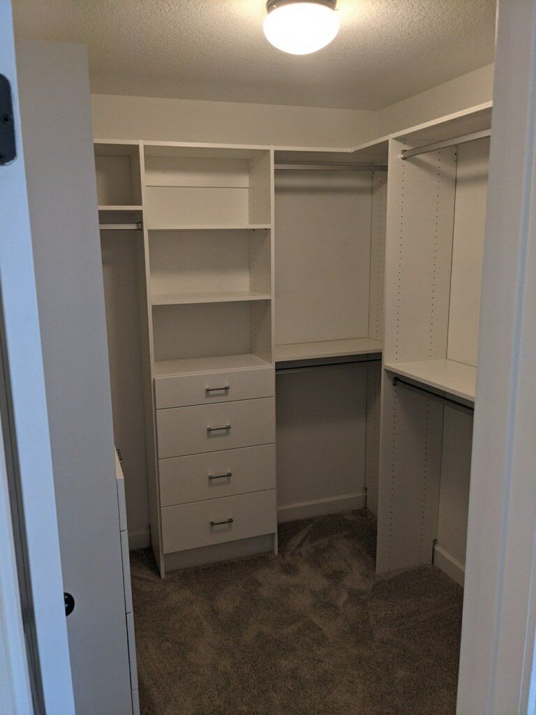 A walk in closet with lots of shelves and drawers.