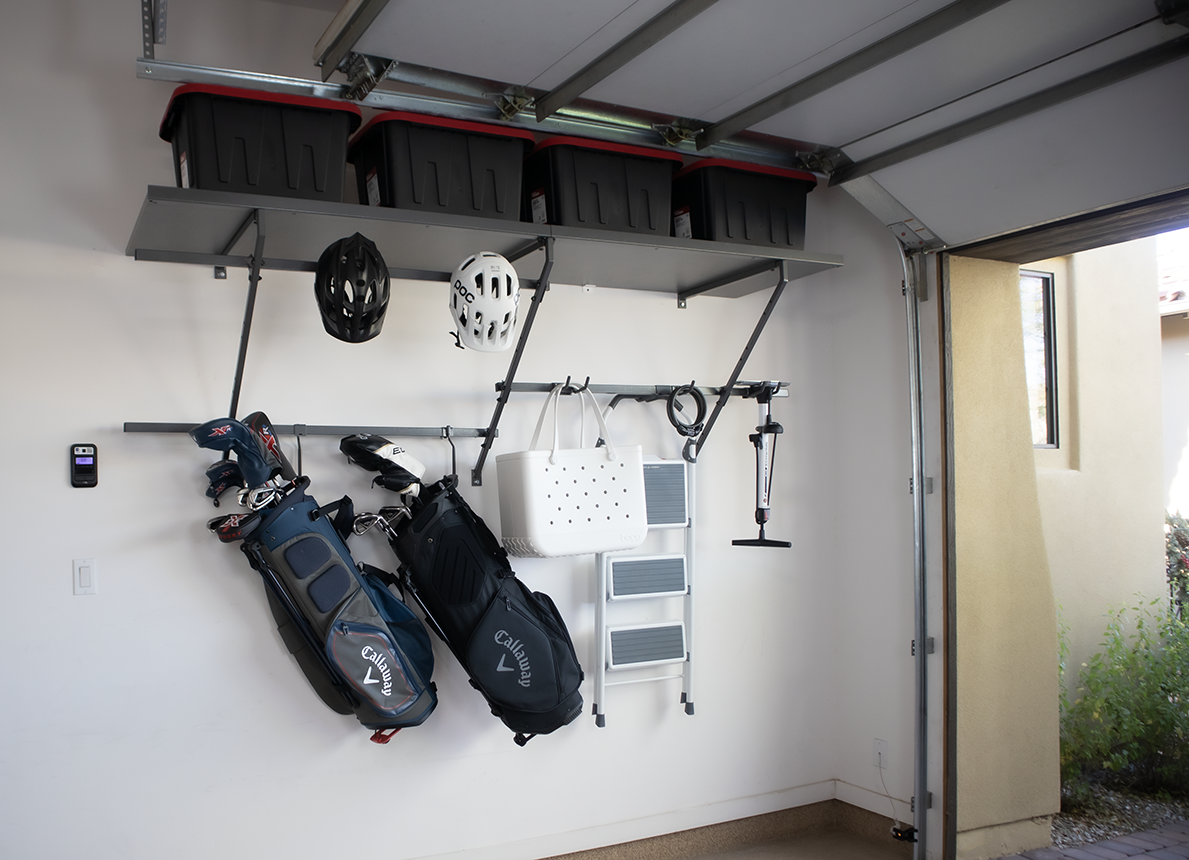 Garage storage unit with shelves and hanging golf bags, helmets, and tote.