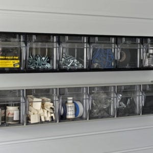 A bunch of clear bins filled with various items on a wall.