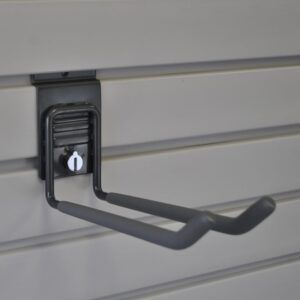 A black hook is attached to a slat wall.