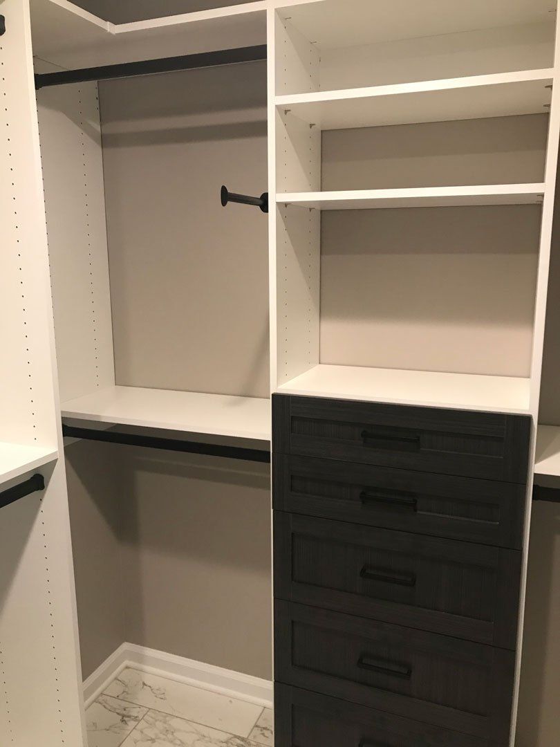 A walk in closet with lots of shelves and drawers.