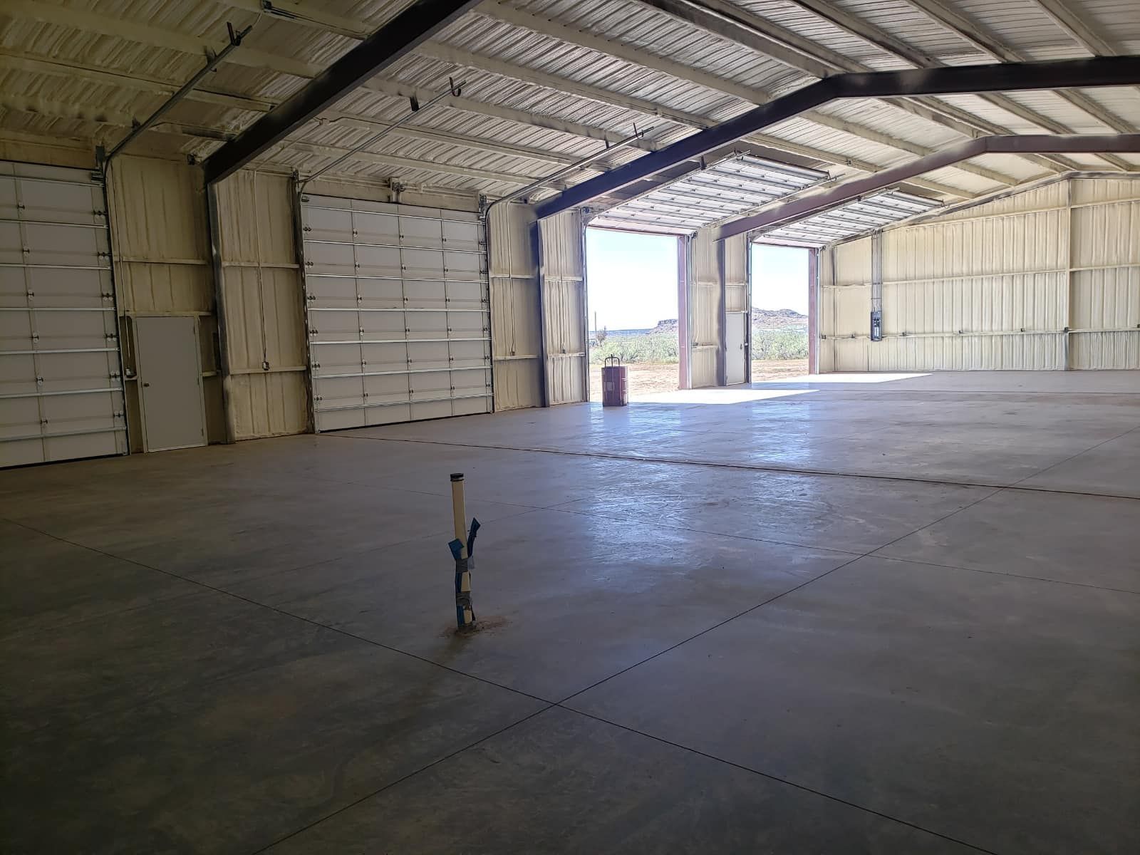A large empty warehouse with a pipe in the middle