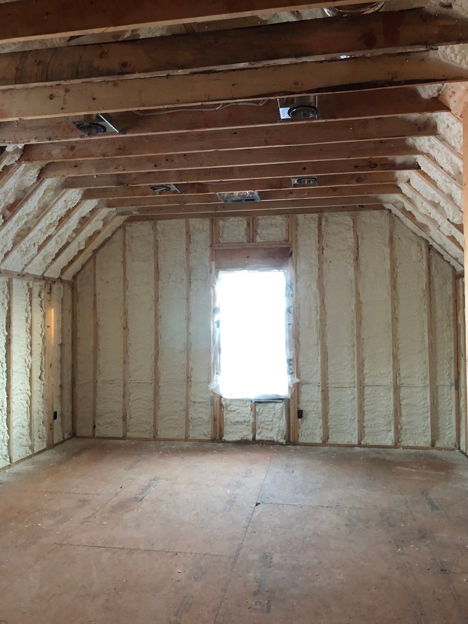 An empty room with a window and foam on the walls.
