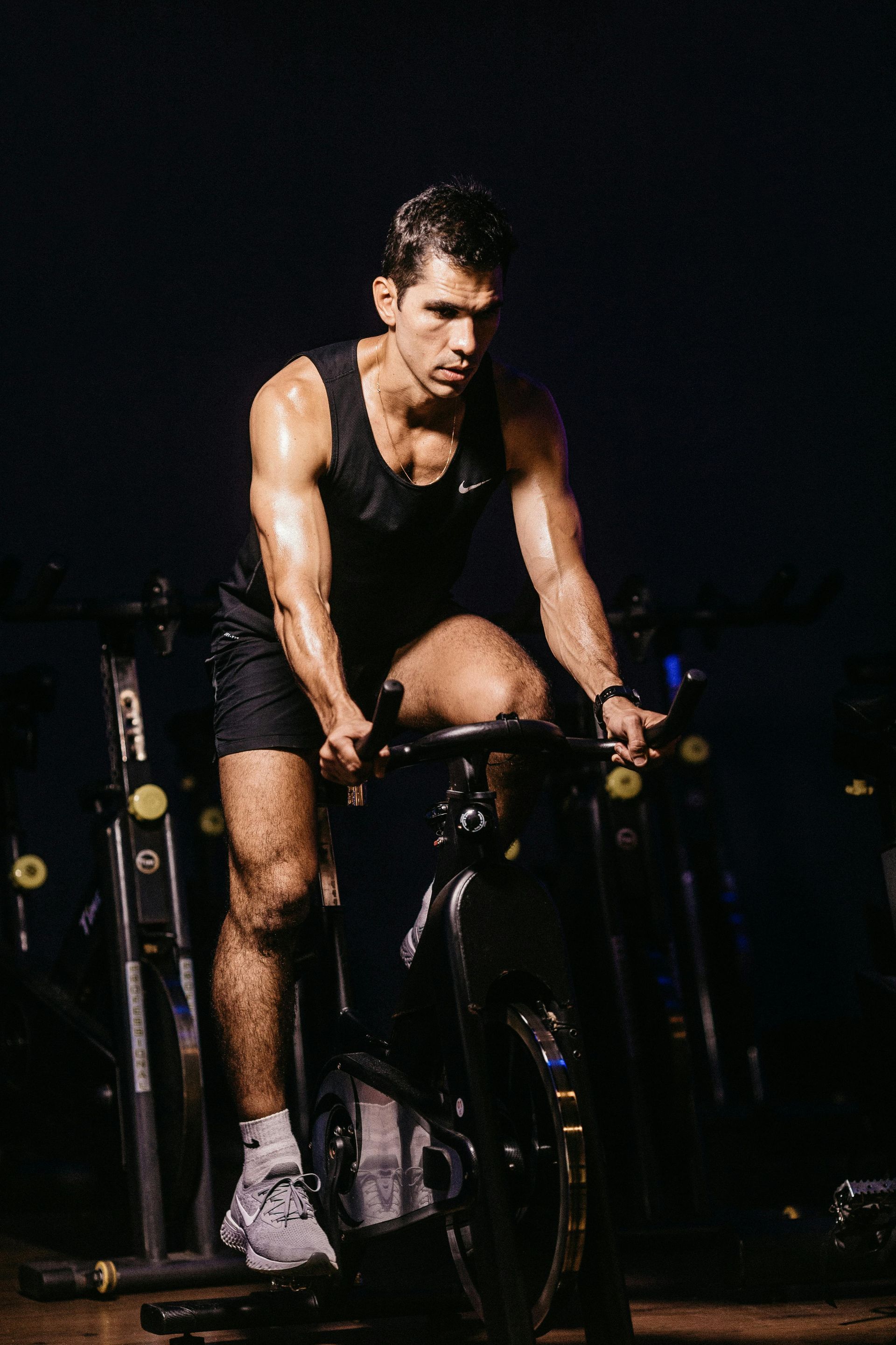 A man is riding an exercise bike in a gym.
