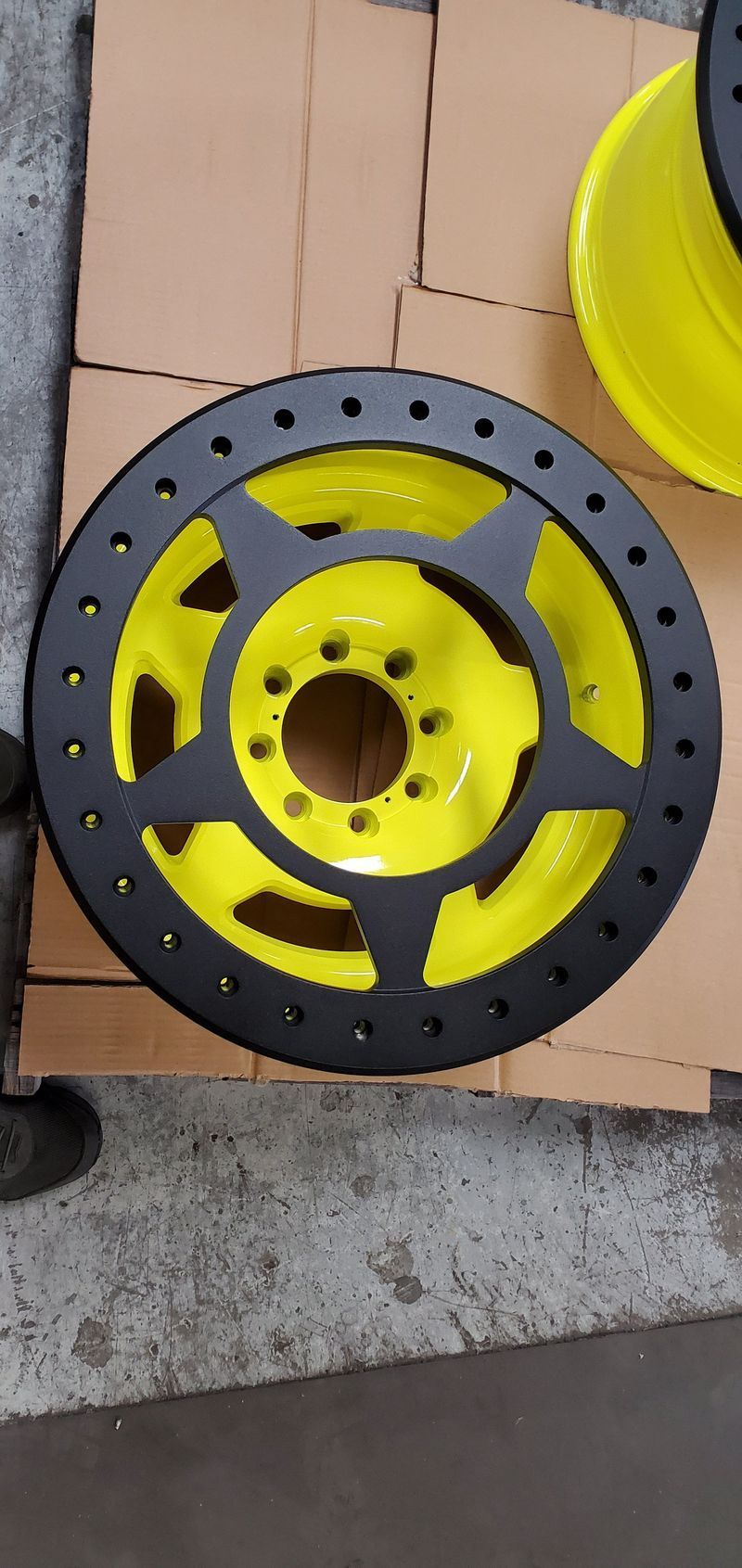 A Yellow and Black Wheel is Sitting on a Cardboard Box