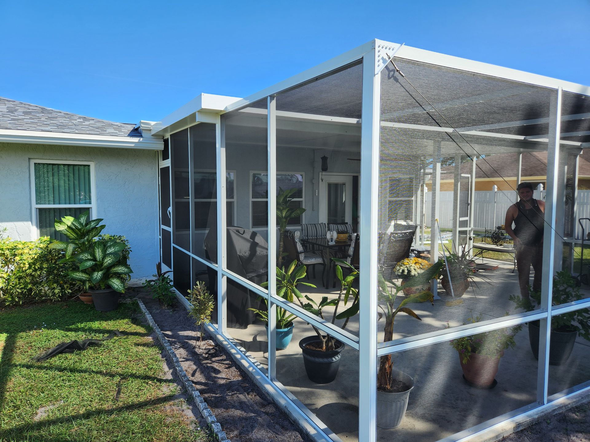 A screened in porch with a table and chairs
