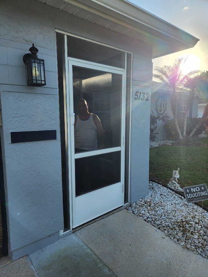 A screened in porch with a door and a window.
