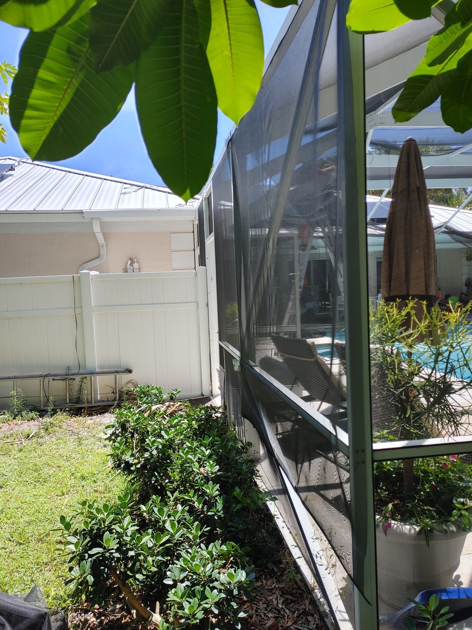 A house with a screened in swimming pool in the backyard.