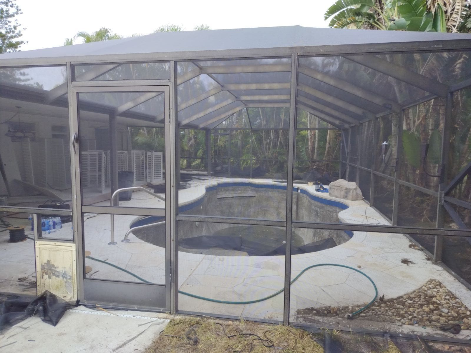 A screened in area with a swimming pool in the background