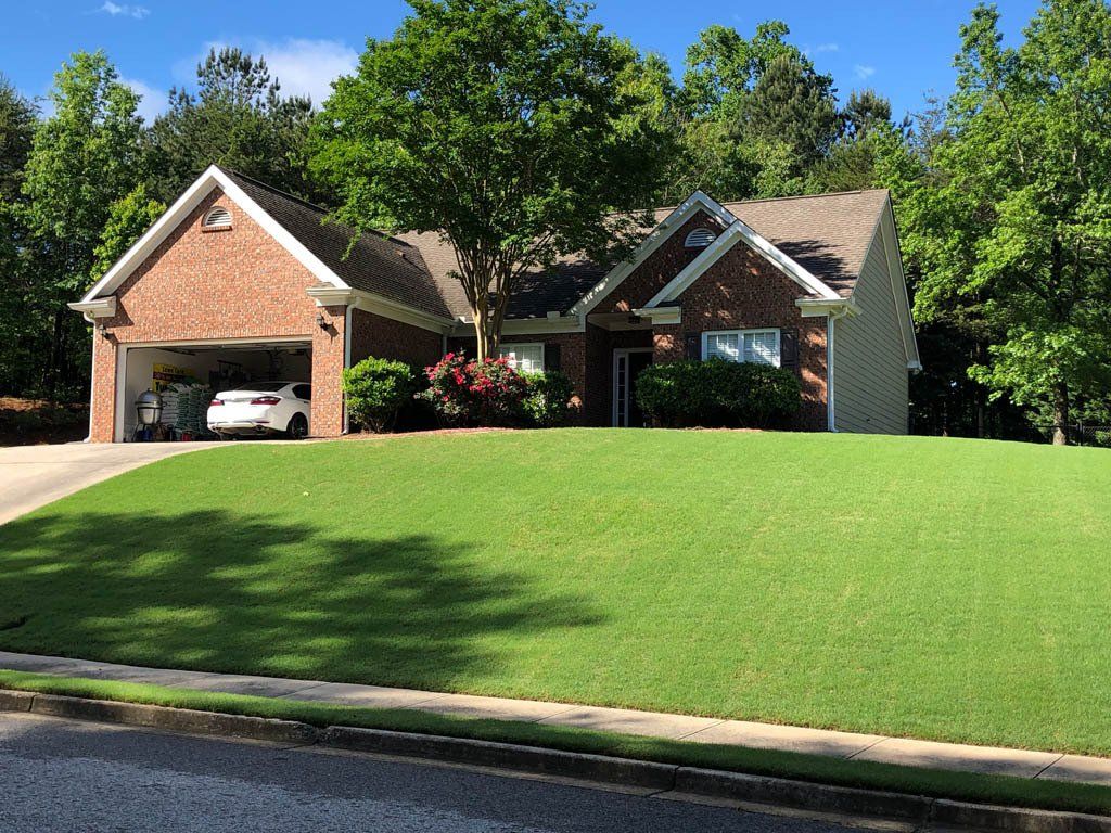 A large brick house with a car parked in the driveway.