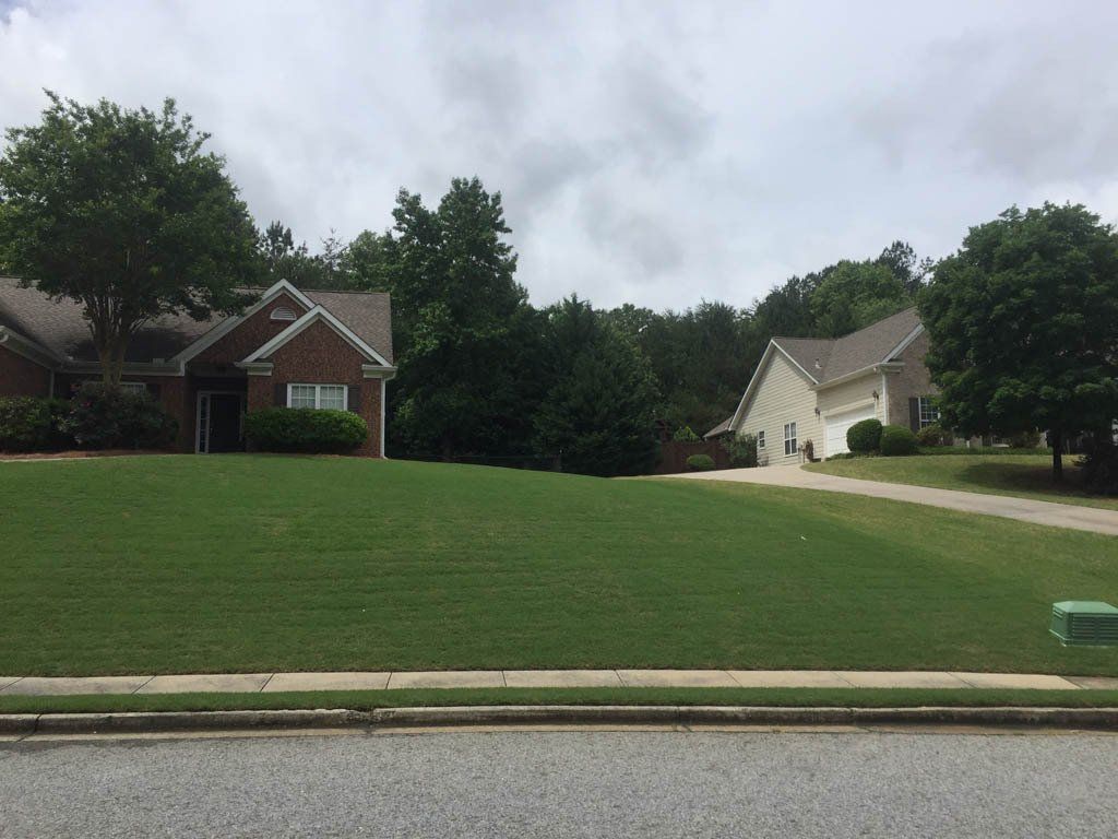 A lush green lawn in front of a brick house