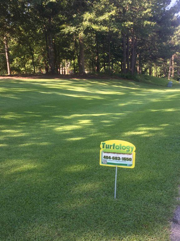 A turfology sign is in the middle of a golf course