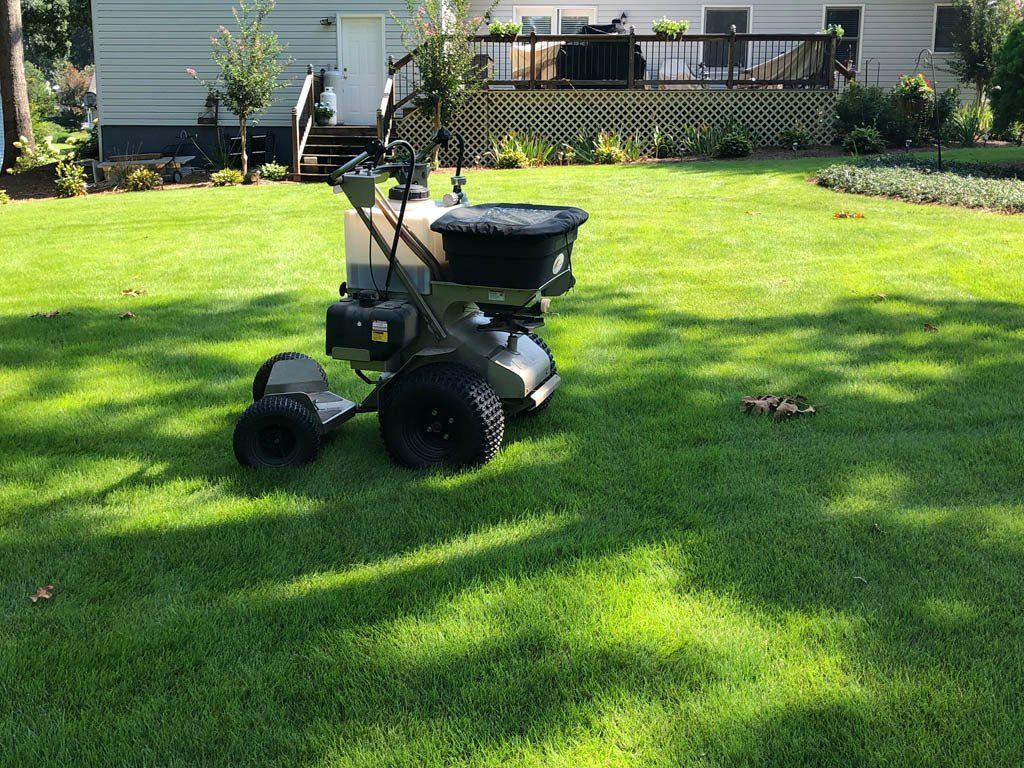 A lawn mower is sitting on top of a lush green lawn.