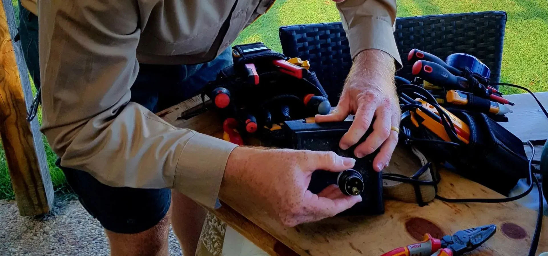 A man is sitting at a table working on a camera.