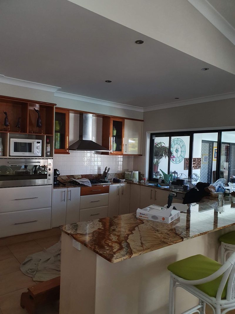 A kitchen with granite counter tops and white cabinets