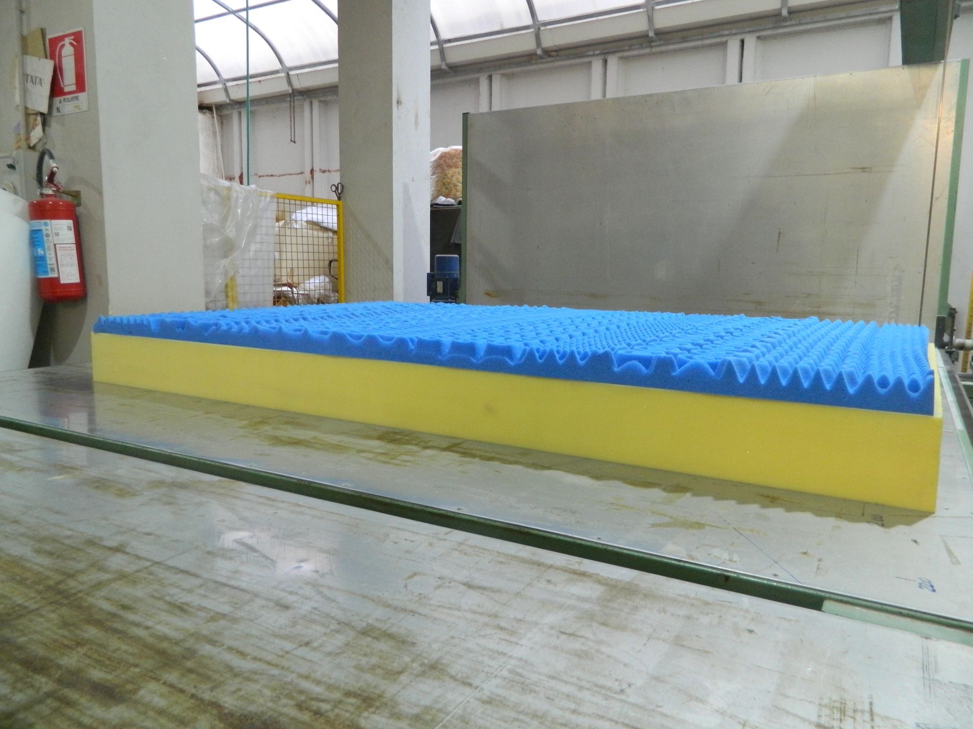 Un materasso blu e giallo è appoggiato su un tavolo di vetro