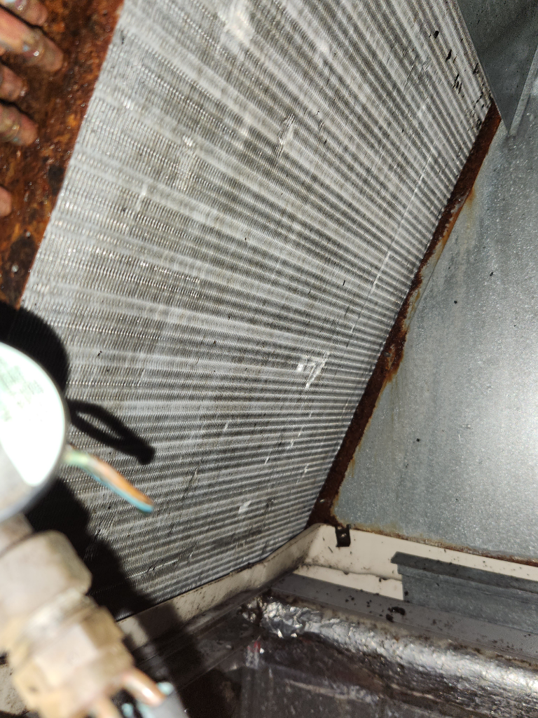 A close up of a rusty radiator in a room.