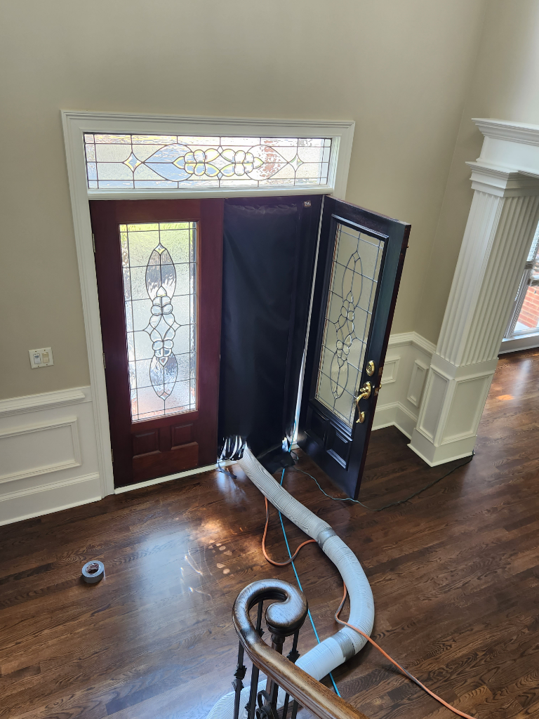 An aerial view of a living room with a staircase and a door.