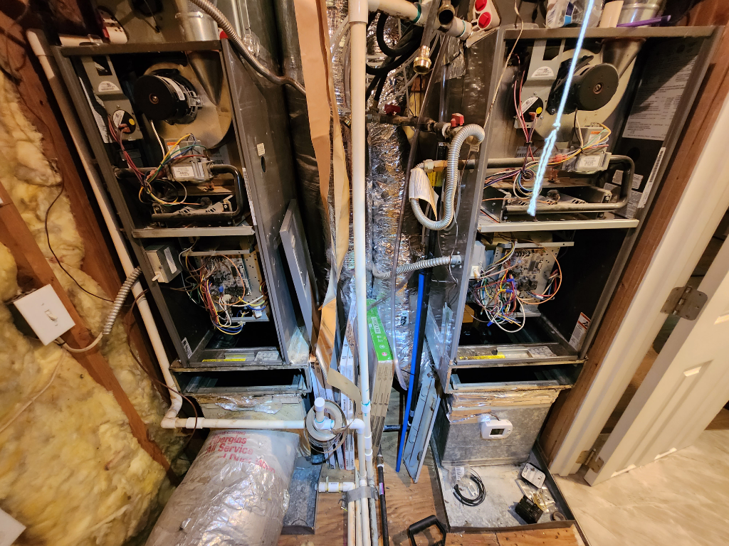 A couple of air conditioners are sitting next to each other in a room.