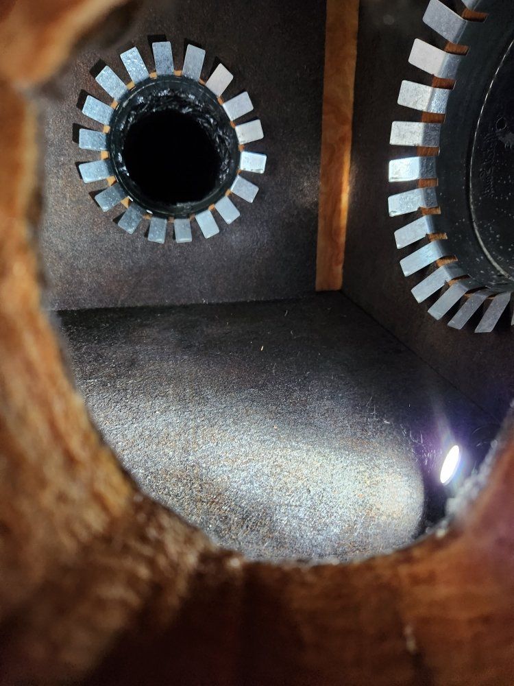 A close up of a hole in a wall with a light coming out of it.