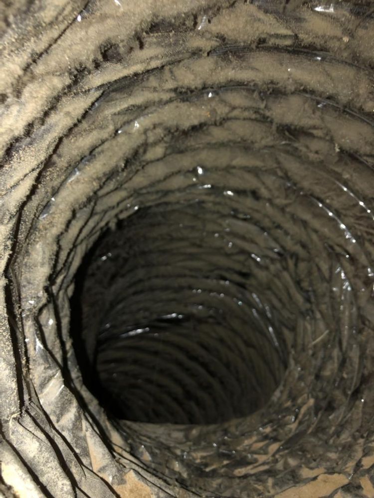 A close up of a dirty air duct with a hole in the middle.