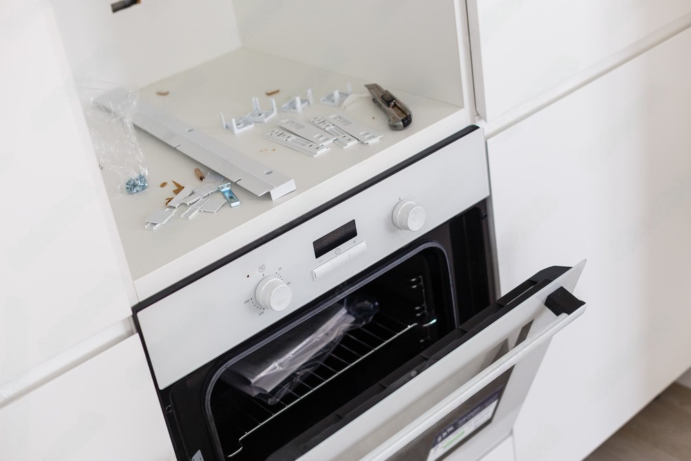 a white oven with the door open in a kitchen .