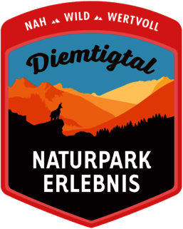 Ein Logo für Naturpark Erlebnis mit einem Wolf auf einem Berggipfel