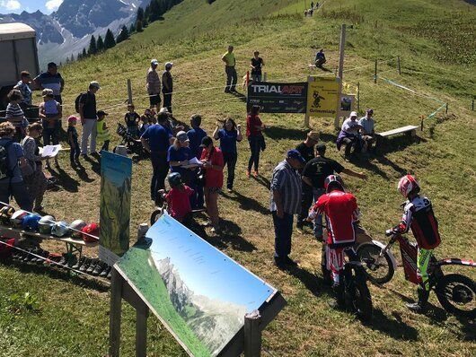 Eine Gruppe von Menschen steht auf einem grasbewachsenen Hügel.