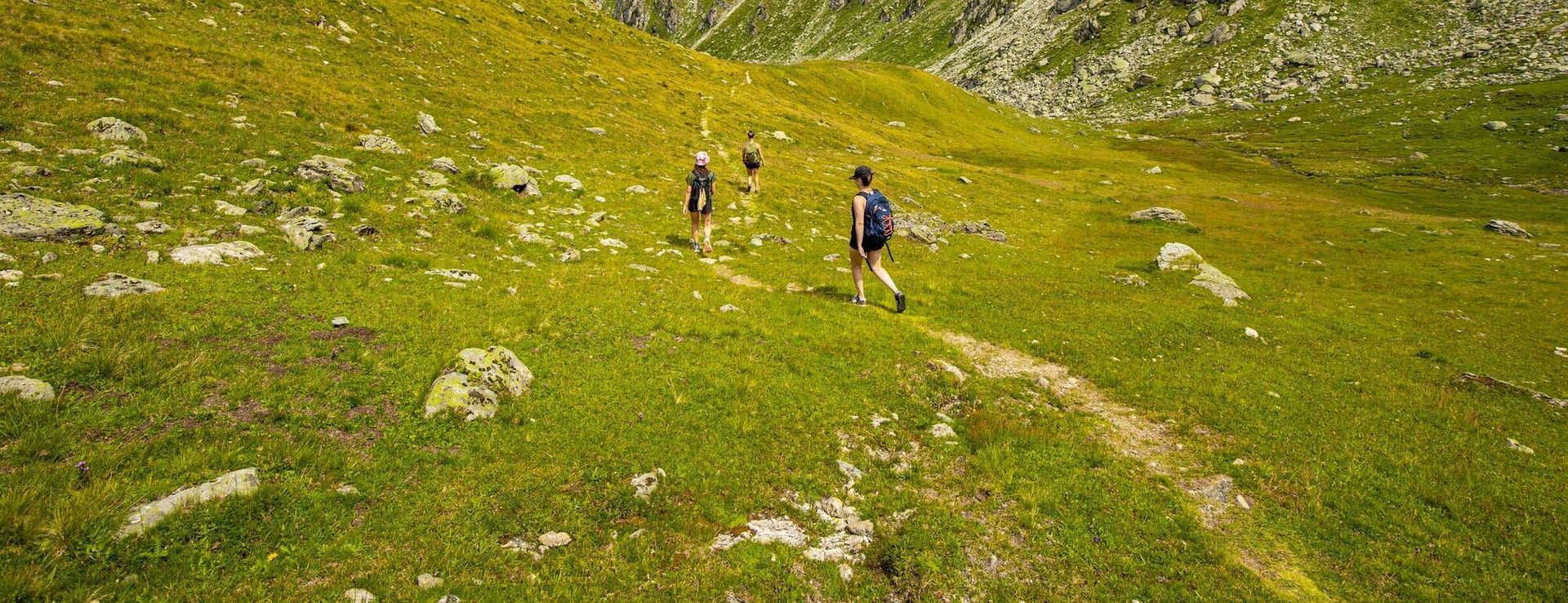 Eine Gruppe von Menschen wandert auf einem Pfad in den Bergen.