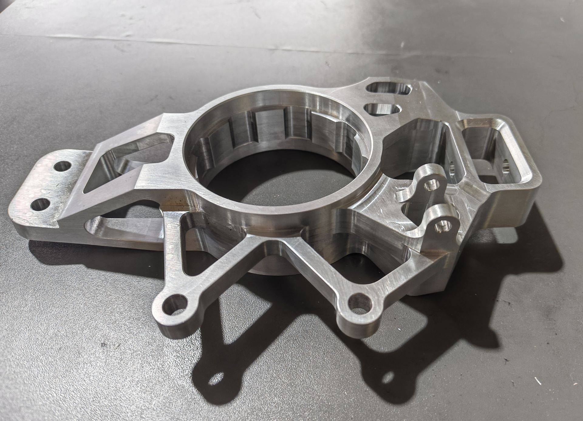 Silberfarbenes, aufwendig gearbeitetes Maschinenteil mit geätzten Verzierungen und dem Wort „HOMEBUILT“.