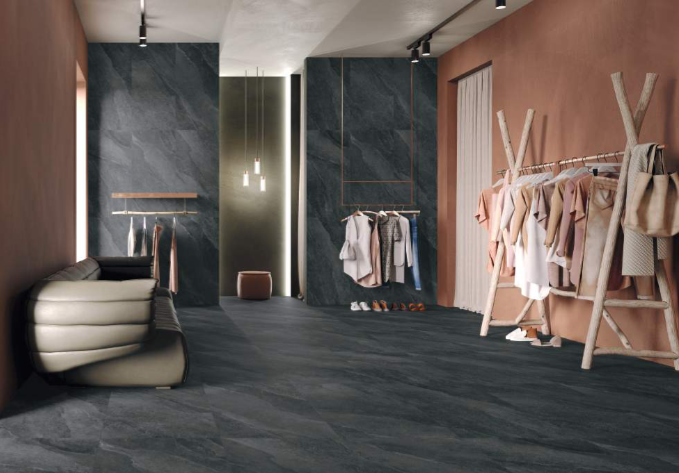 Moderna garderobna omara s temnimi kamnitimi tlemi, stenami in koralno roza barvo. 