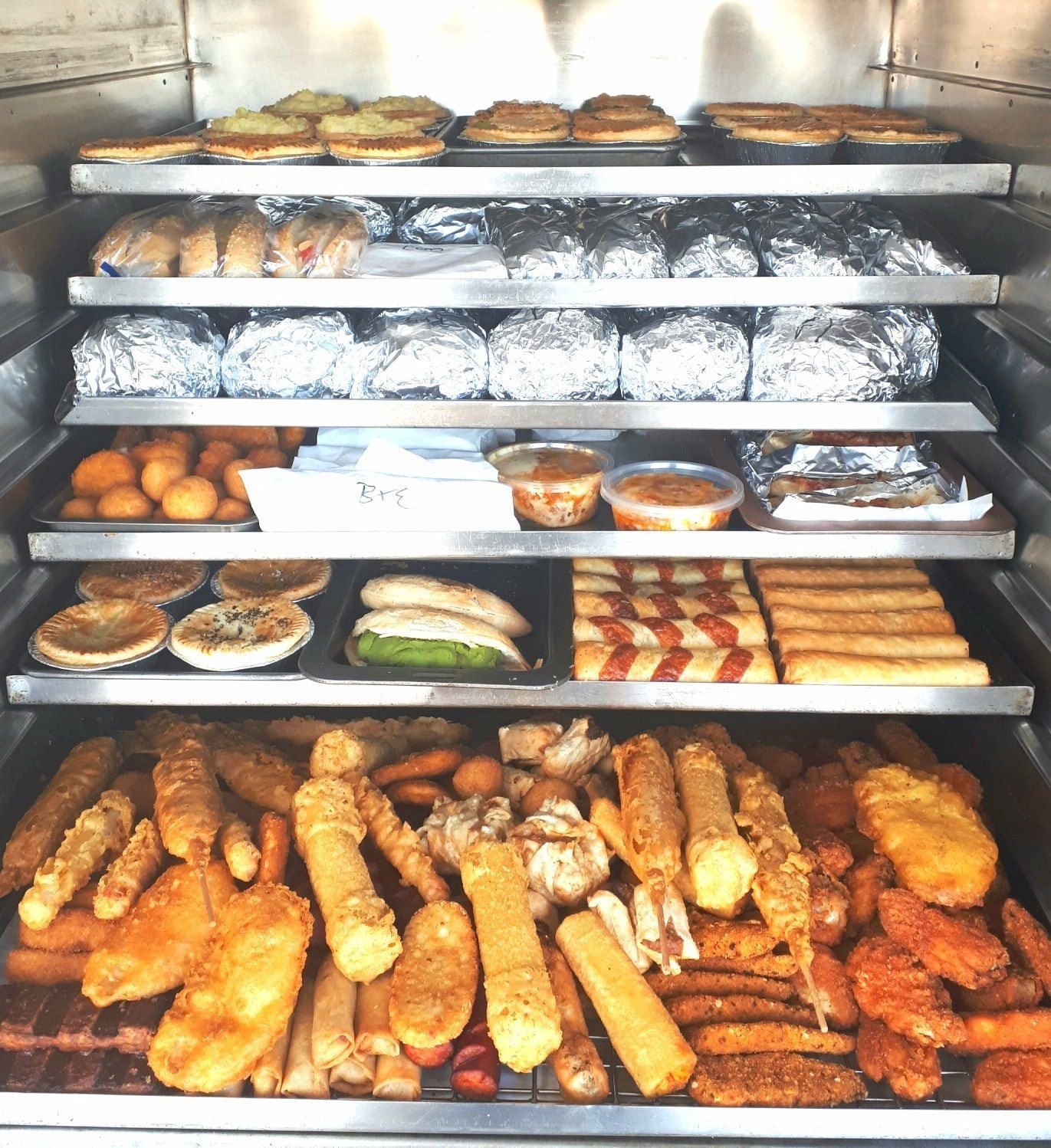 A Cabinet Filled With Various Prepared Food Items, Including Pies — Mels Catering in Clermont, QLD